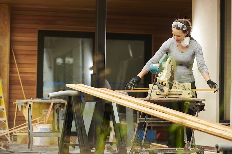 Green home constructino allows us to keep Martha's Vineyard healthy and beautiful. Photo of woman contractor working on exterior of a home.